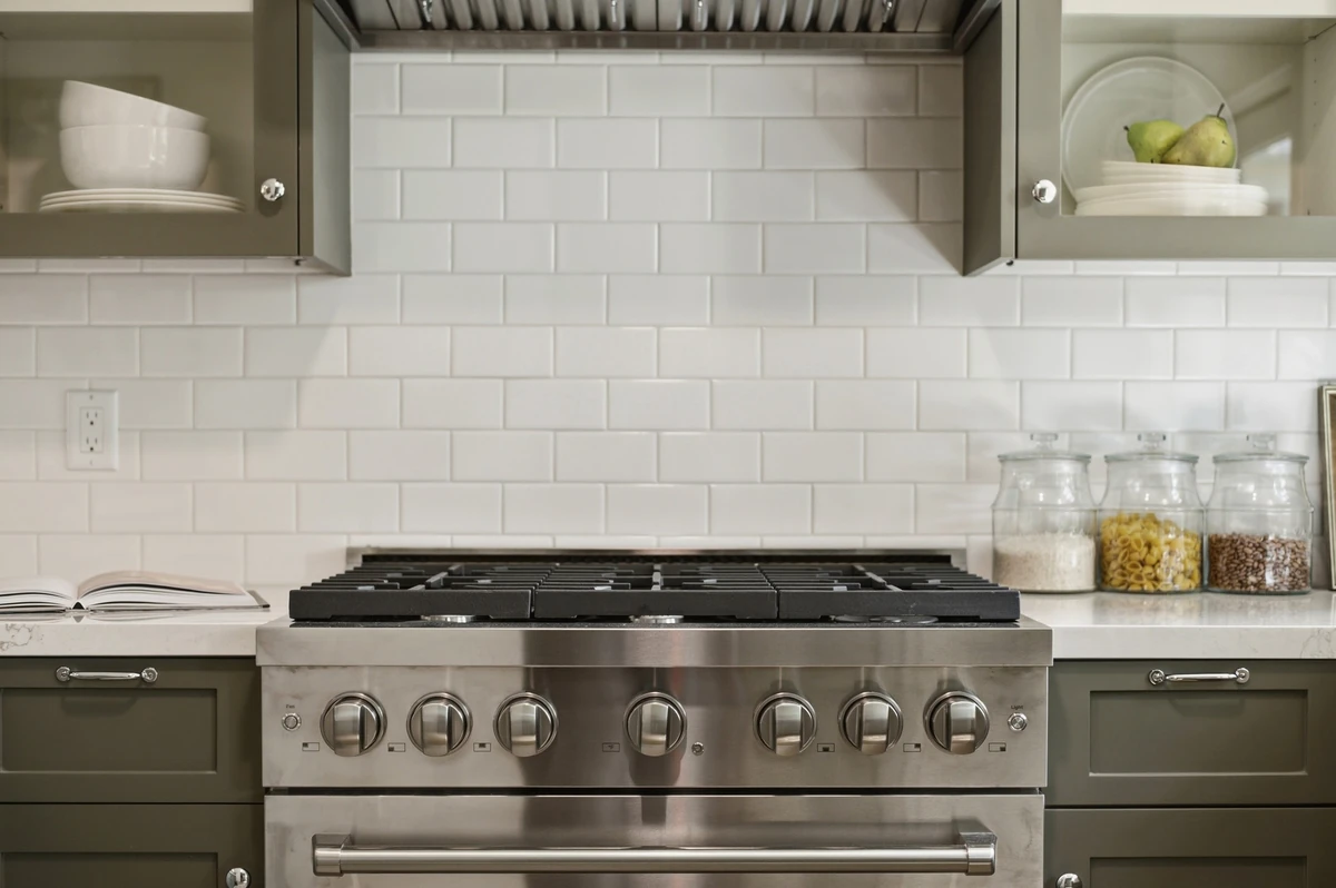 Green Adams Street kitchen cabinetry with a range and white tile