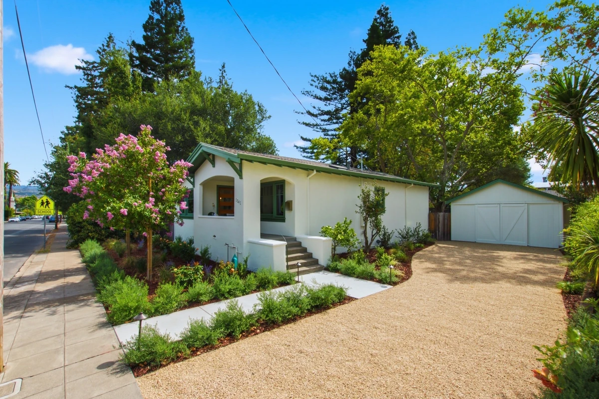 Adams Street home with a covered entry, green trim and landscaped front garden