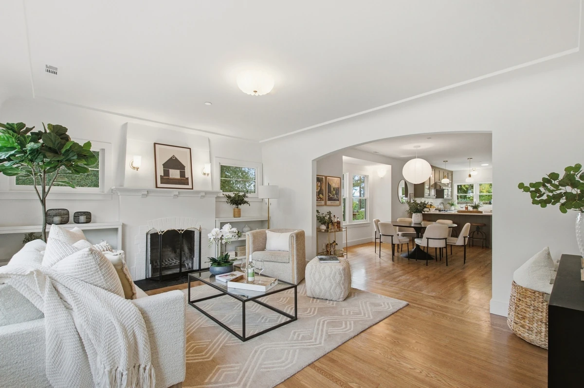Bright Adams Street living room with a fireplace and an arched opening to the dining area