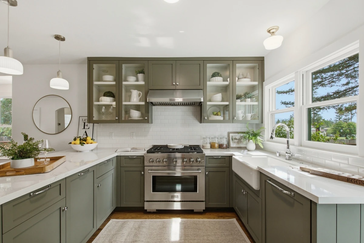 Adams Street kitchen with green cabinetry, white counters and daylight from the windows